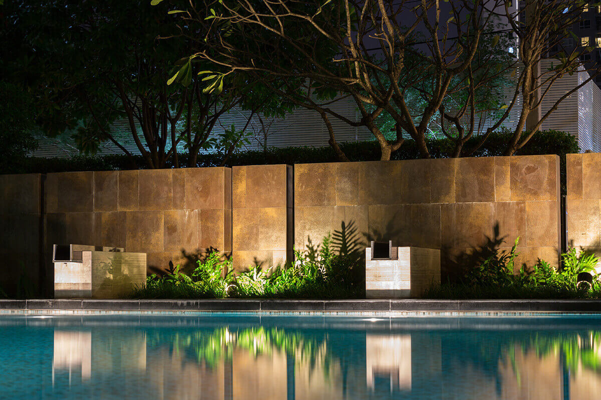 A pool with a beautiful landscape lighting design.